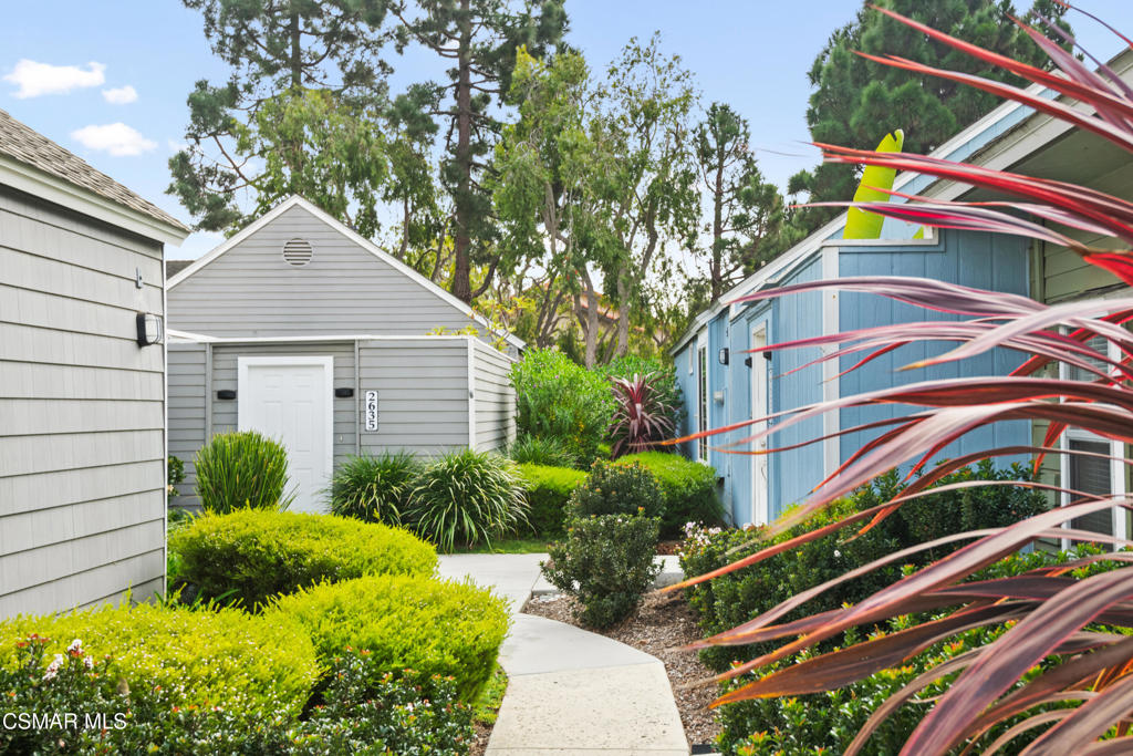 a backyard of a house with plants and outdoor seating