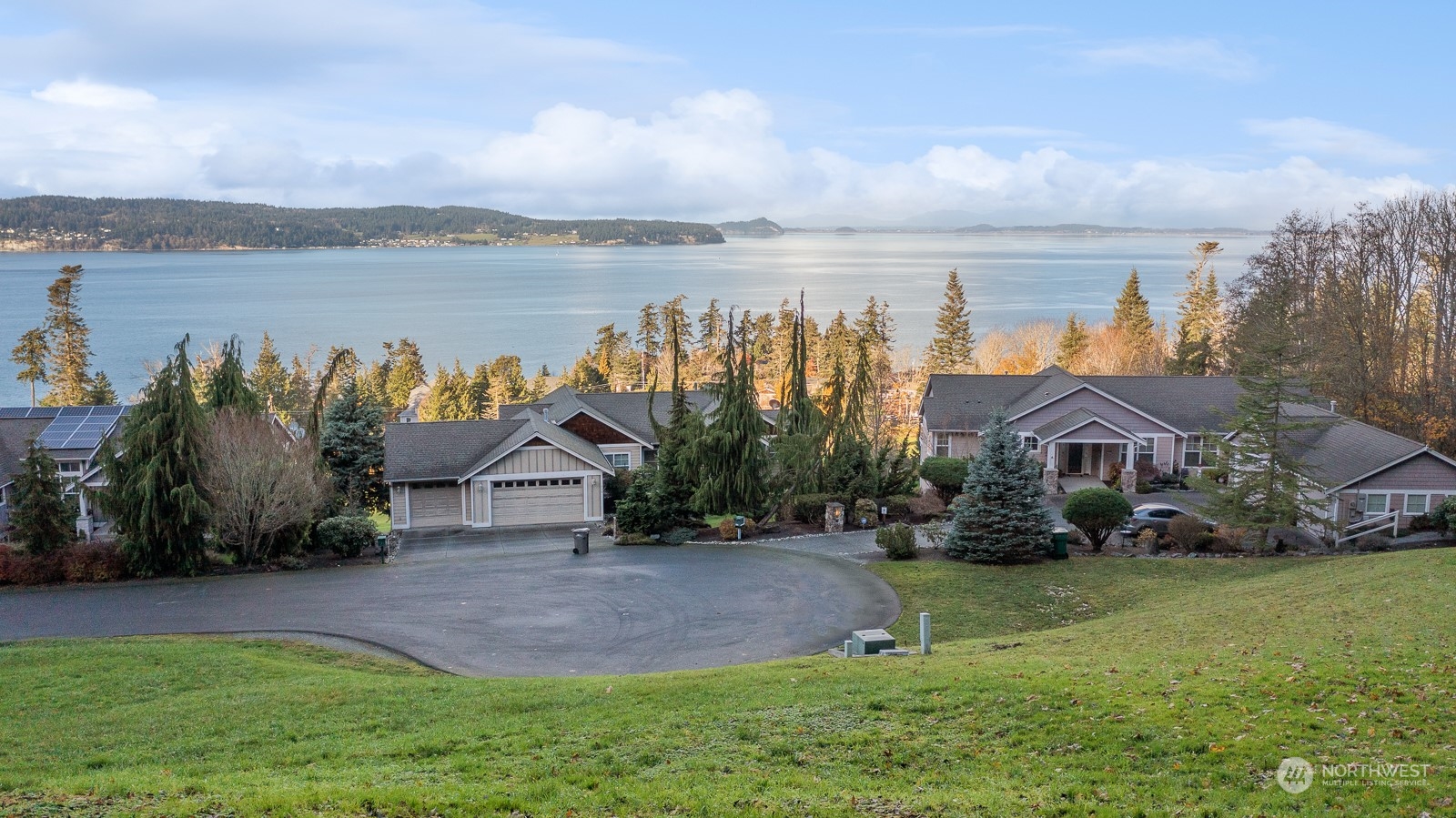 an aerial view of a house with a yard and lake view