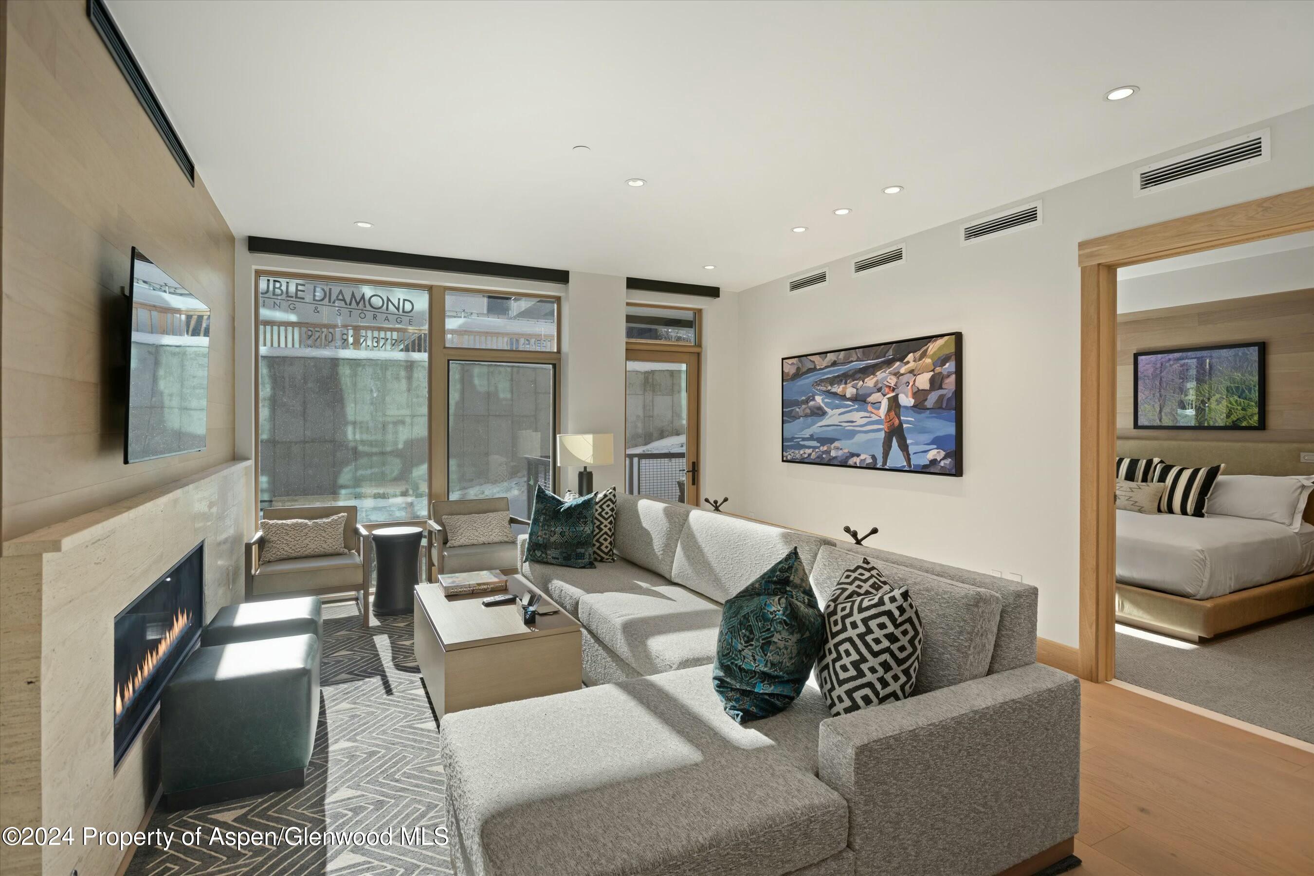 a living room with furniture large window and a fireplace