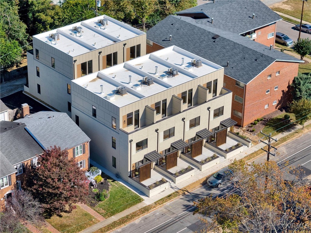 an aerial view of multiple houses with a yard