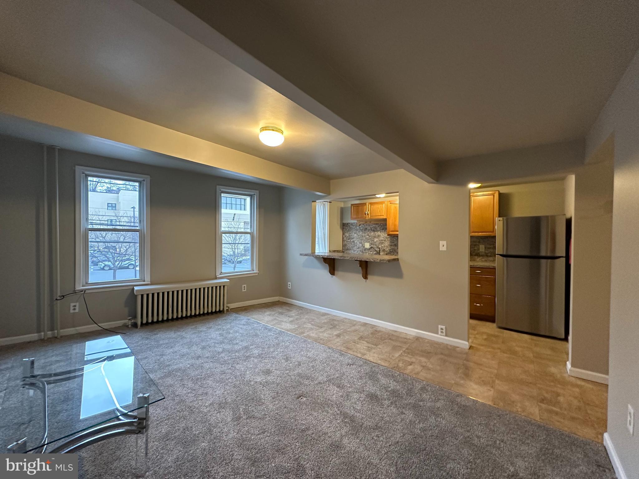 a view of empty room with a kitchen