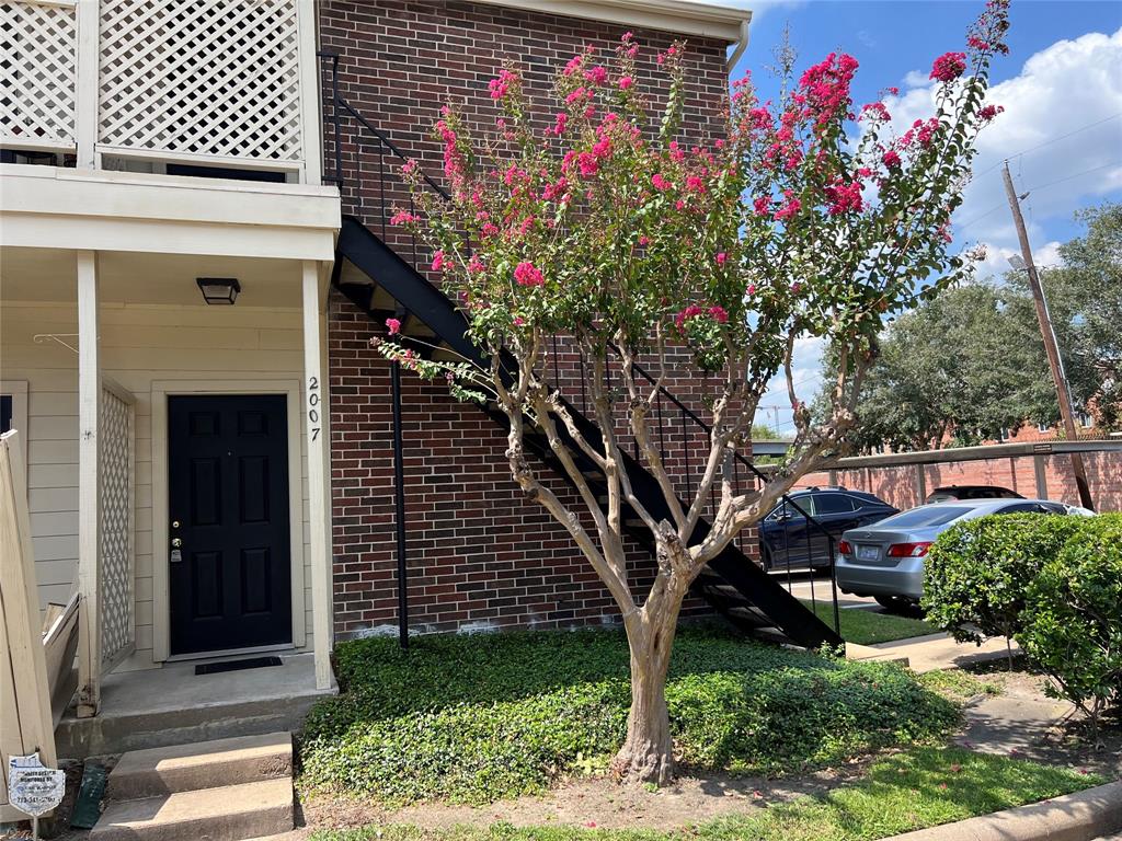 a front view of a house with a tree