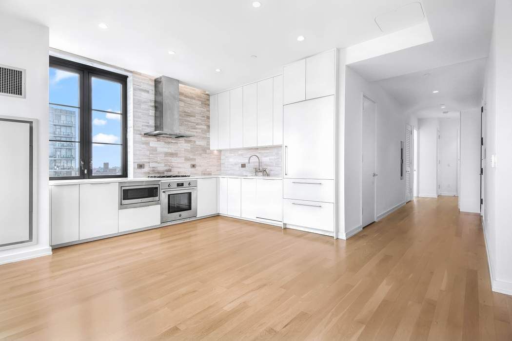 a view of kitchen with stainless steel appliances cabinets and wooden floor