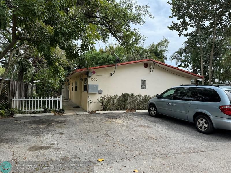 a view of parking space with a car parked in front of a house