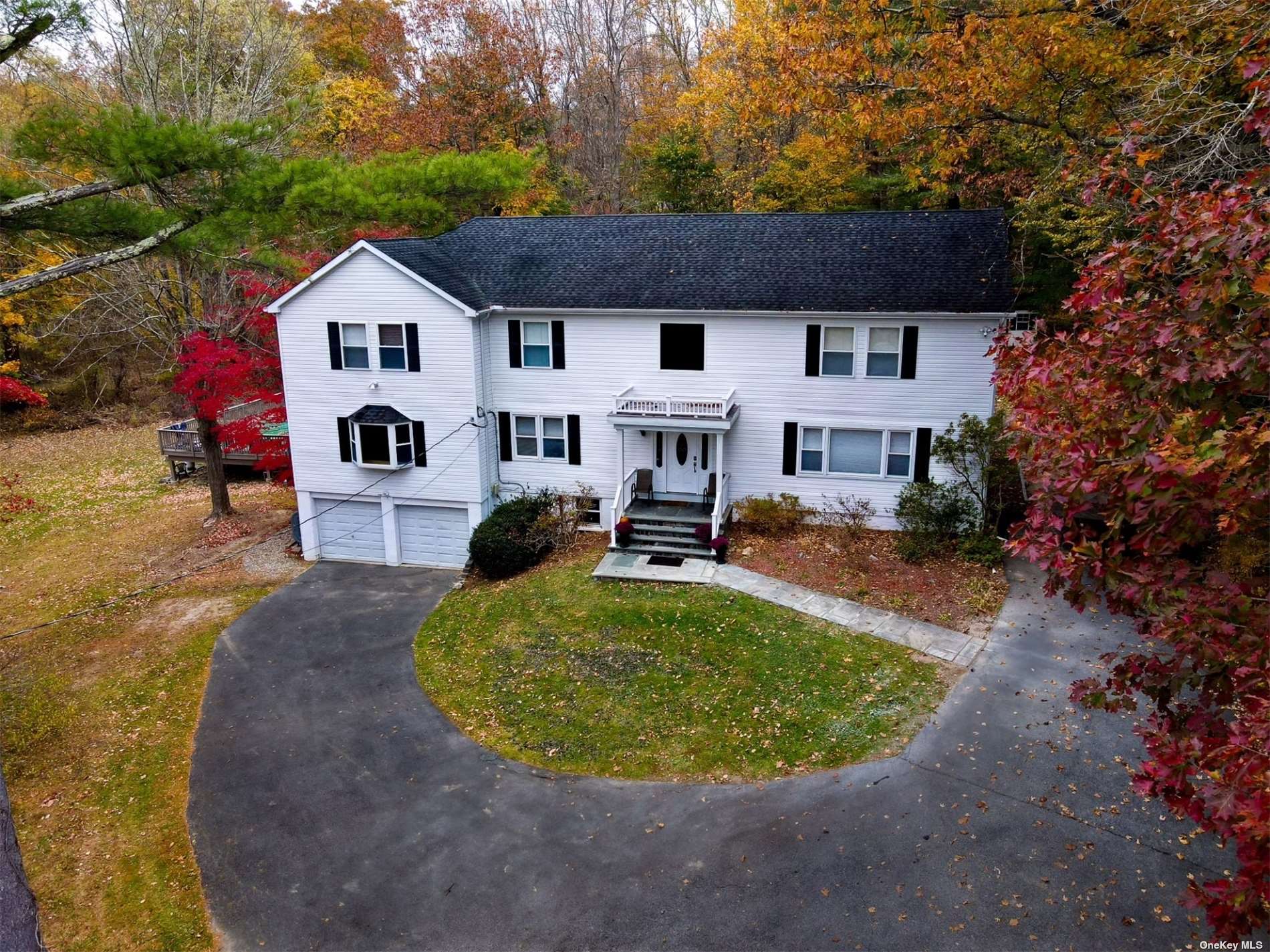 a view of a white house with a yard patio and fire pit