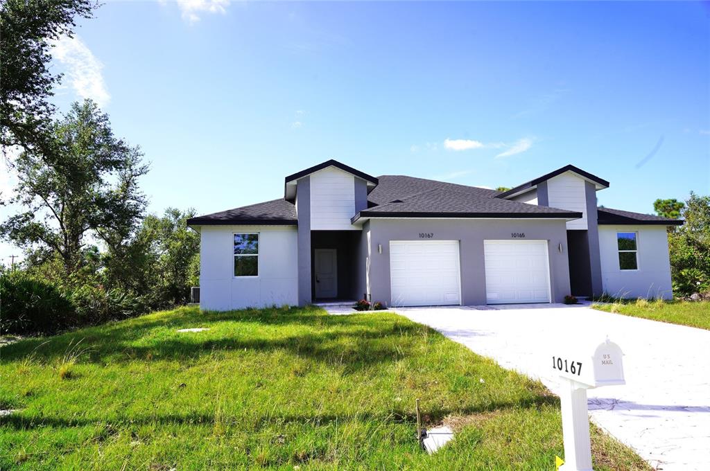 a front view of a house with a yard and garage