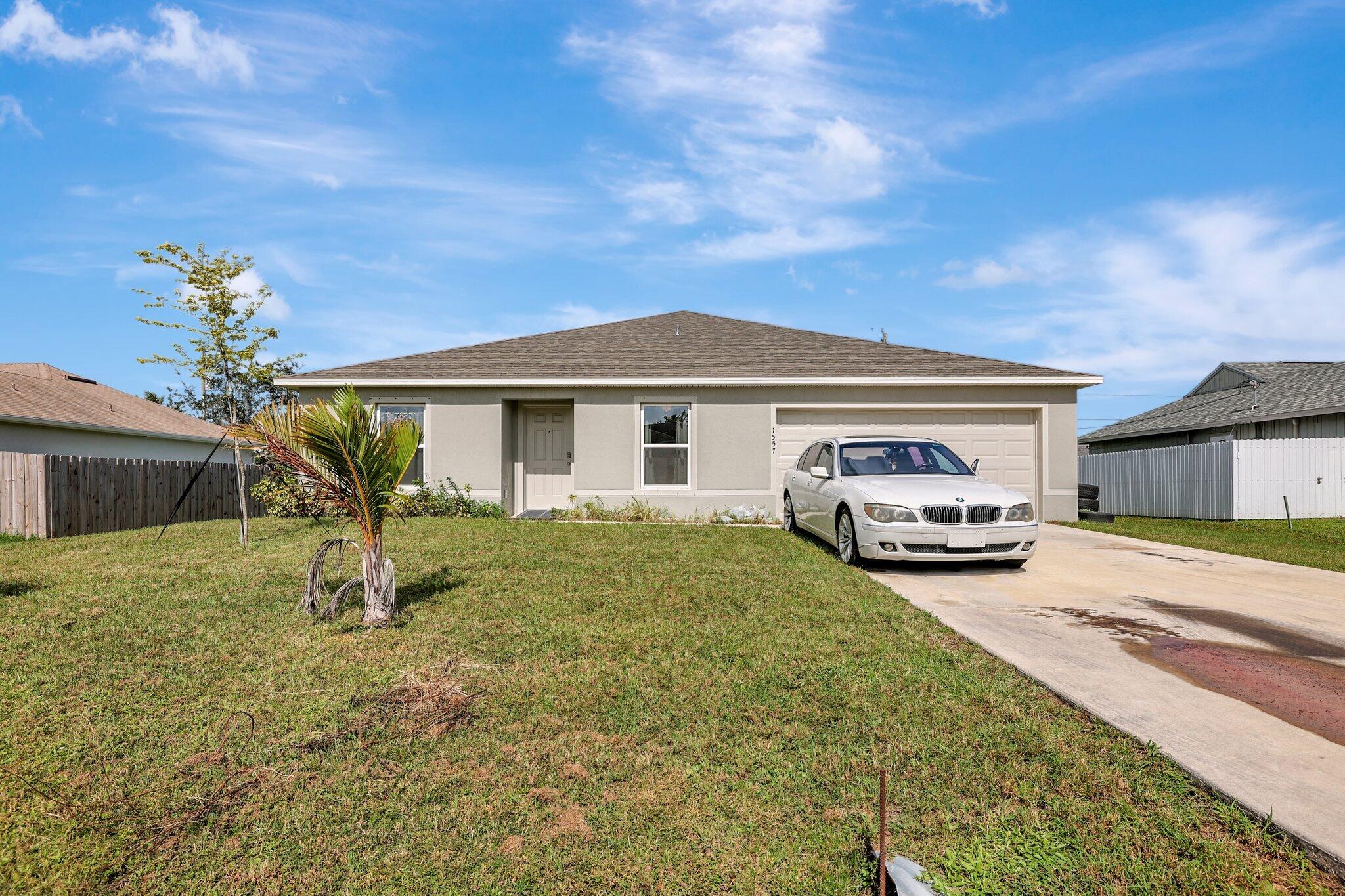 a view of a house with a garden and parking space