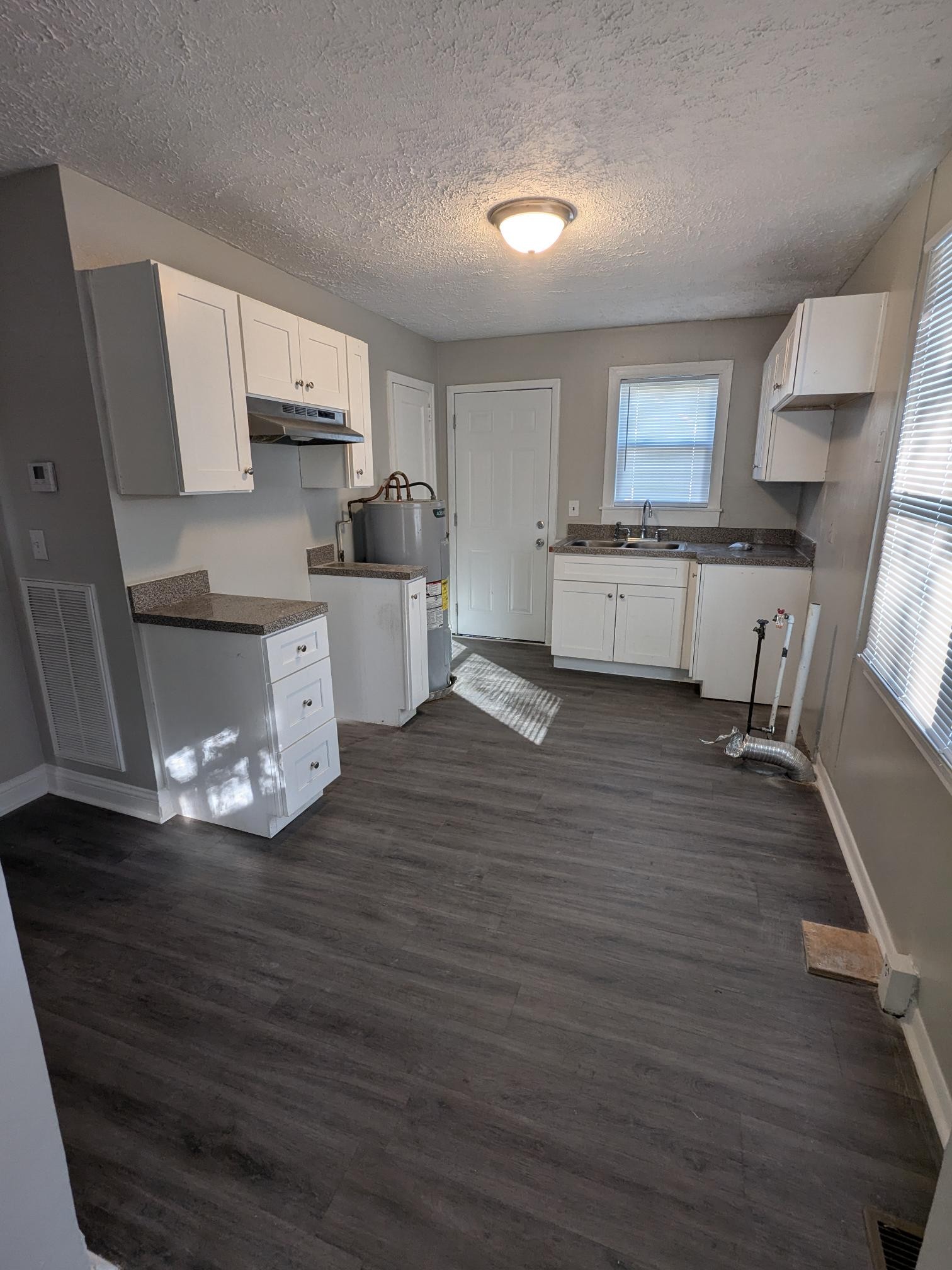 a kitchen with stainless steel appliances wooden floor and a refrigerator