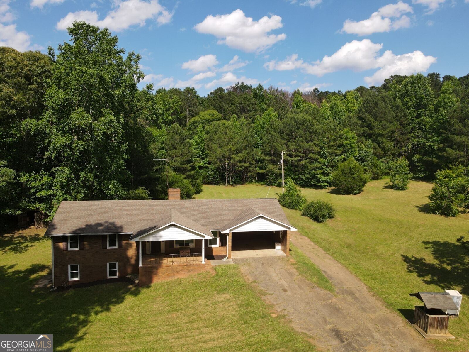 an aerial view of residential houses with yard and mountain view in back