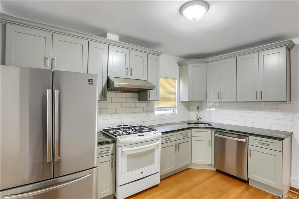 a kitchen with white cabinets and white appliances