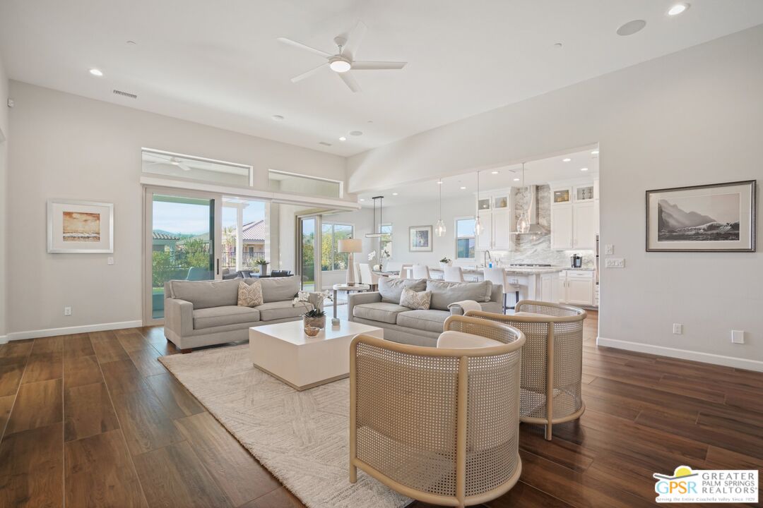 a living room with furniture a wooden floor and a large window