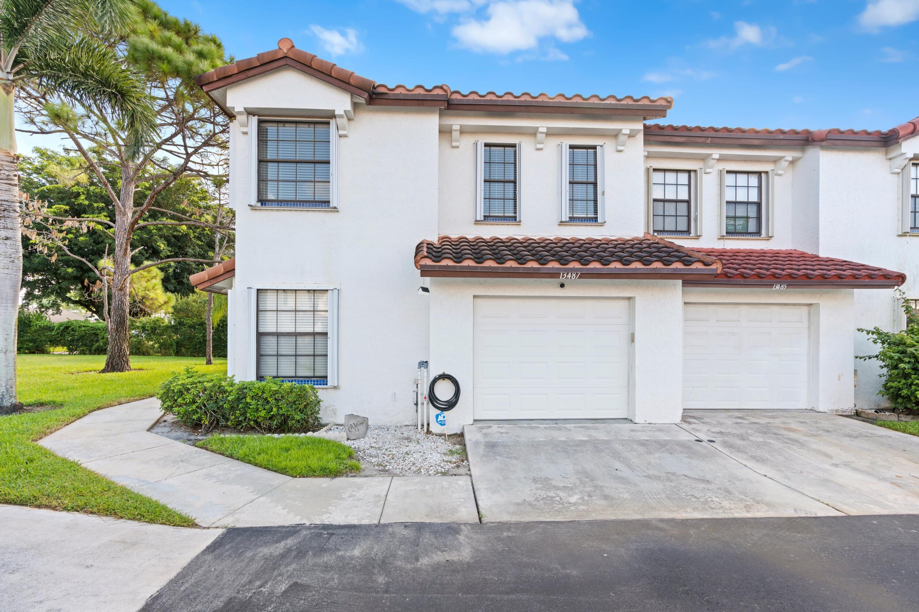 a front view of a house with a yard and a garage