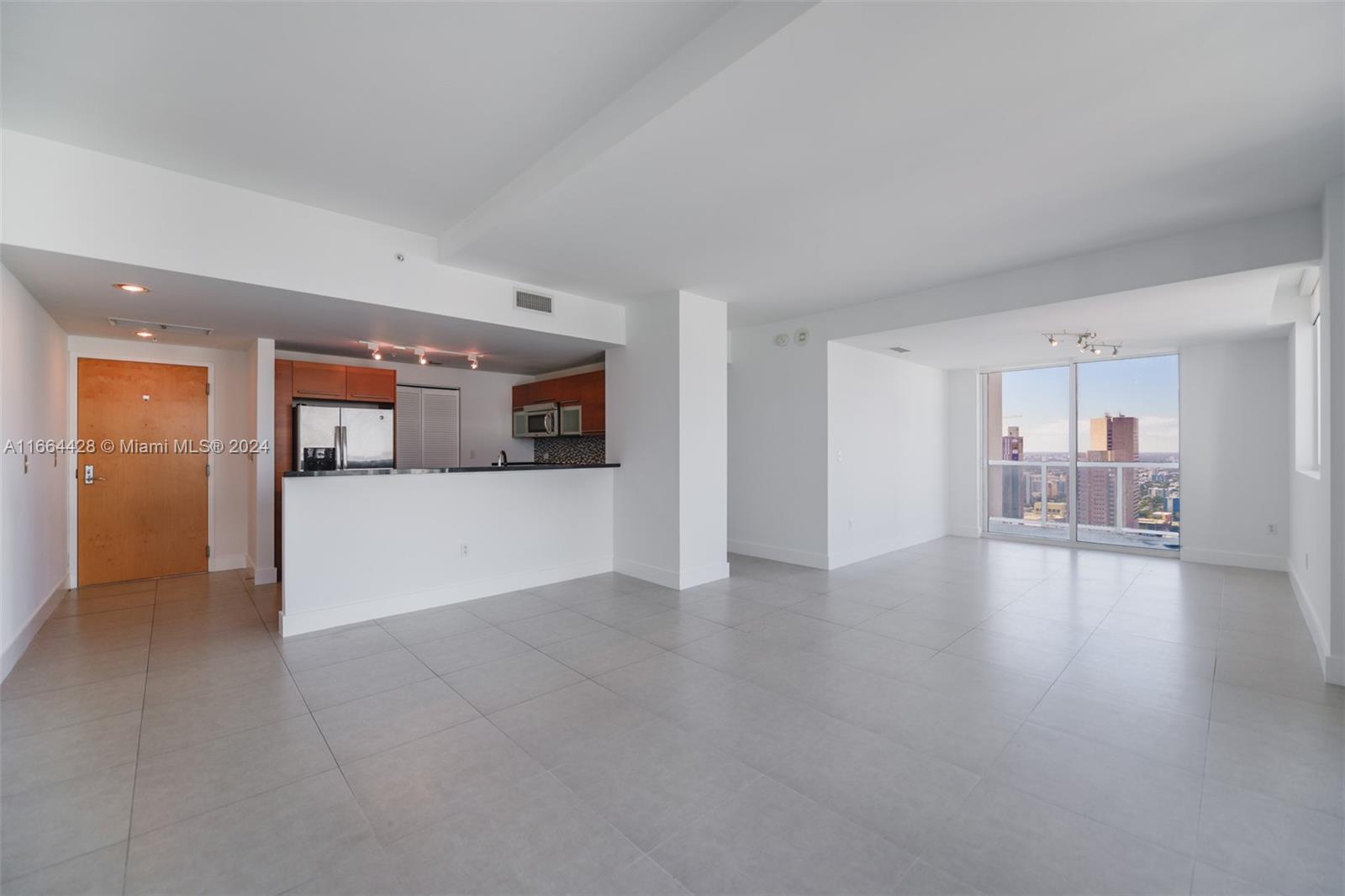 a view of a livingroom with furniture and a kitchen