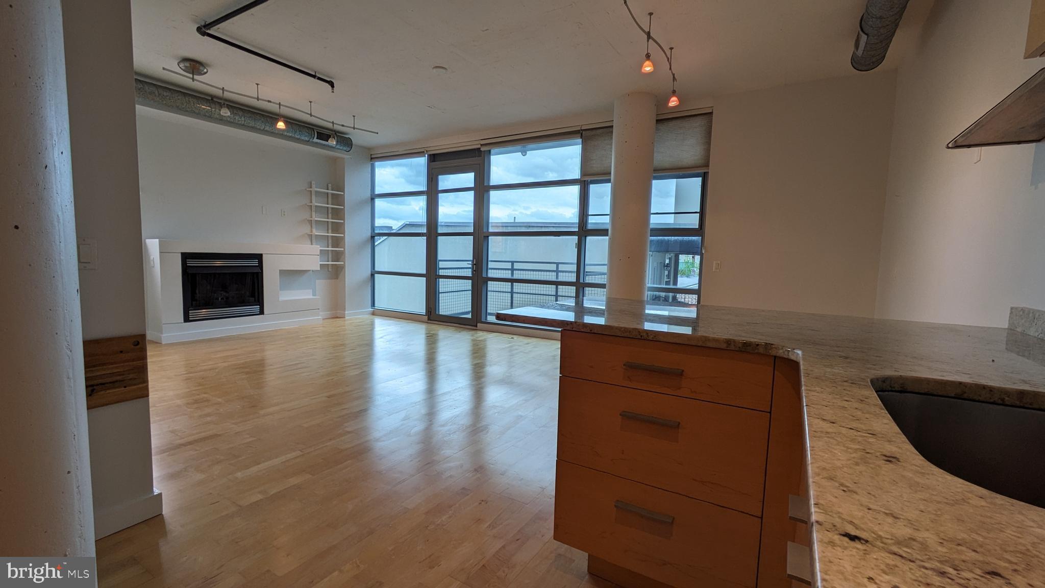 a view of an empty room with a fireplace and a window