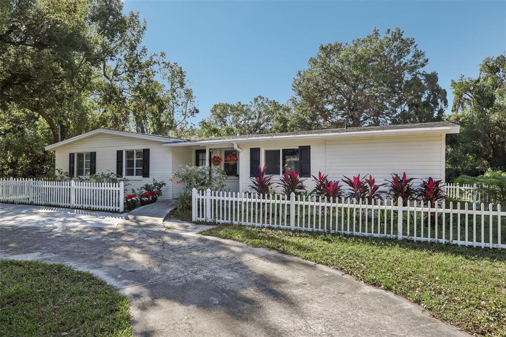 a view of a house with wooden fence and a porch