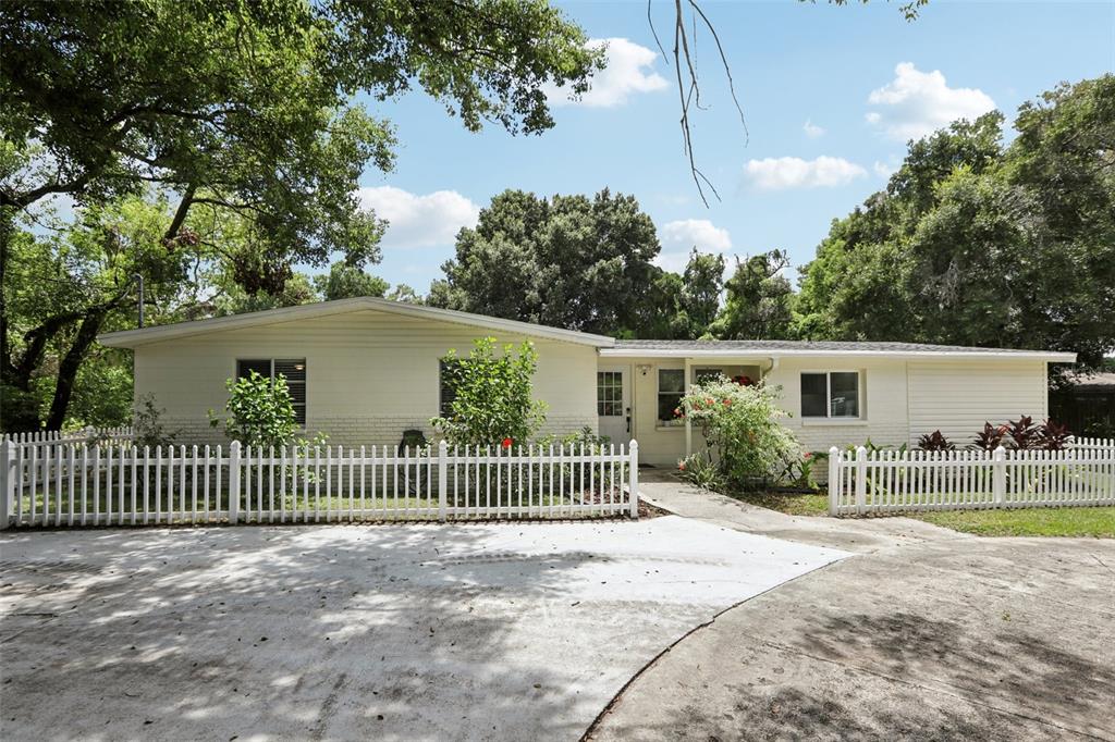 a view of a house with a small yard and wooden fence