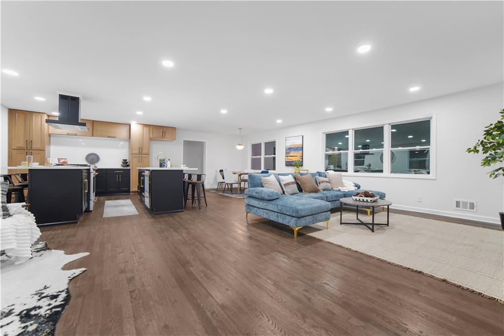 a living room with furniture and a wooden floor