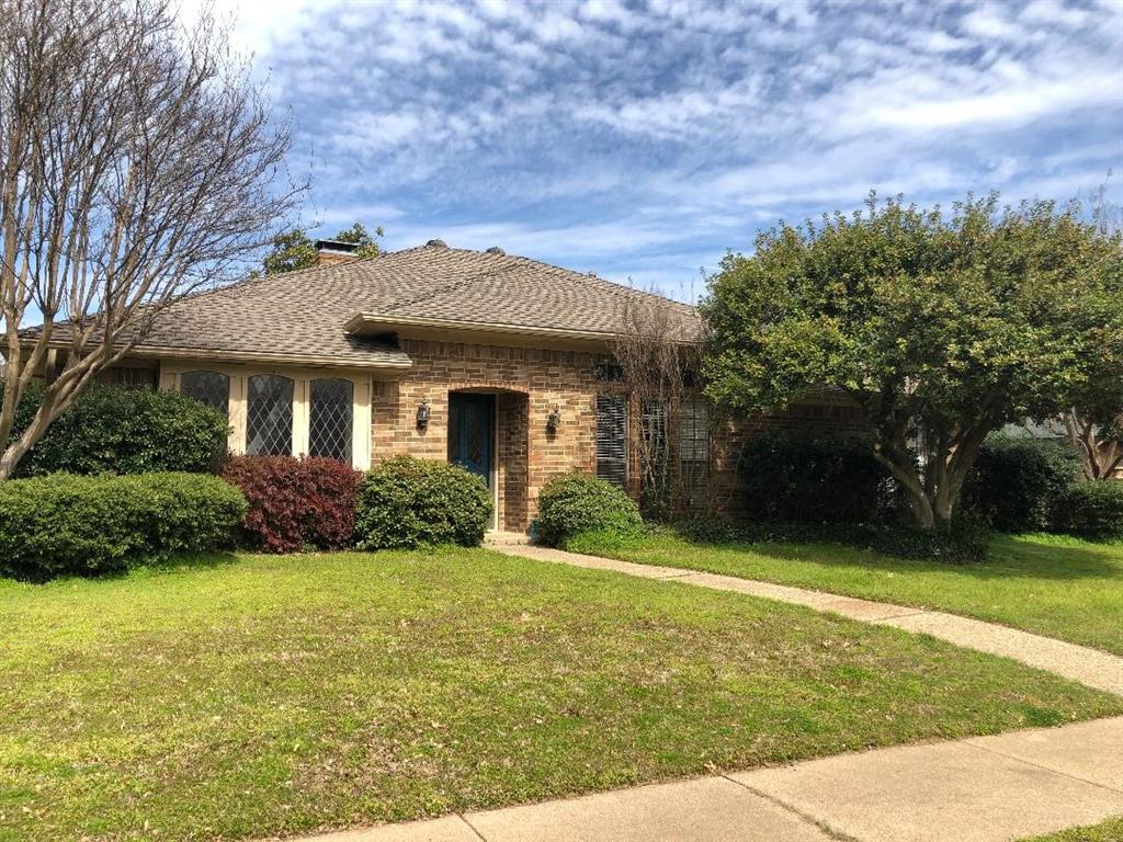 a front view of a house with yard and green space