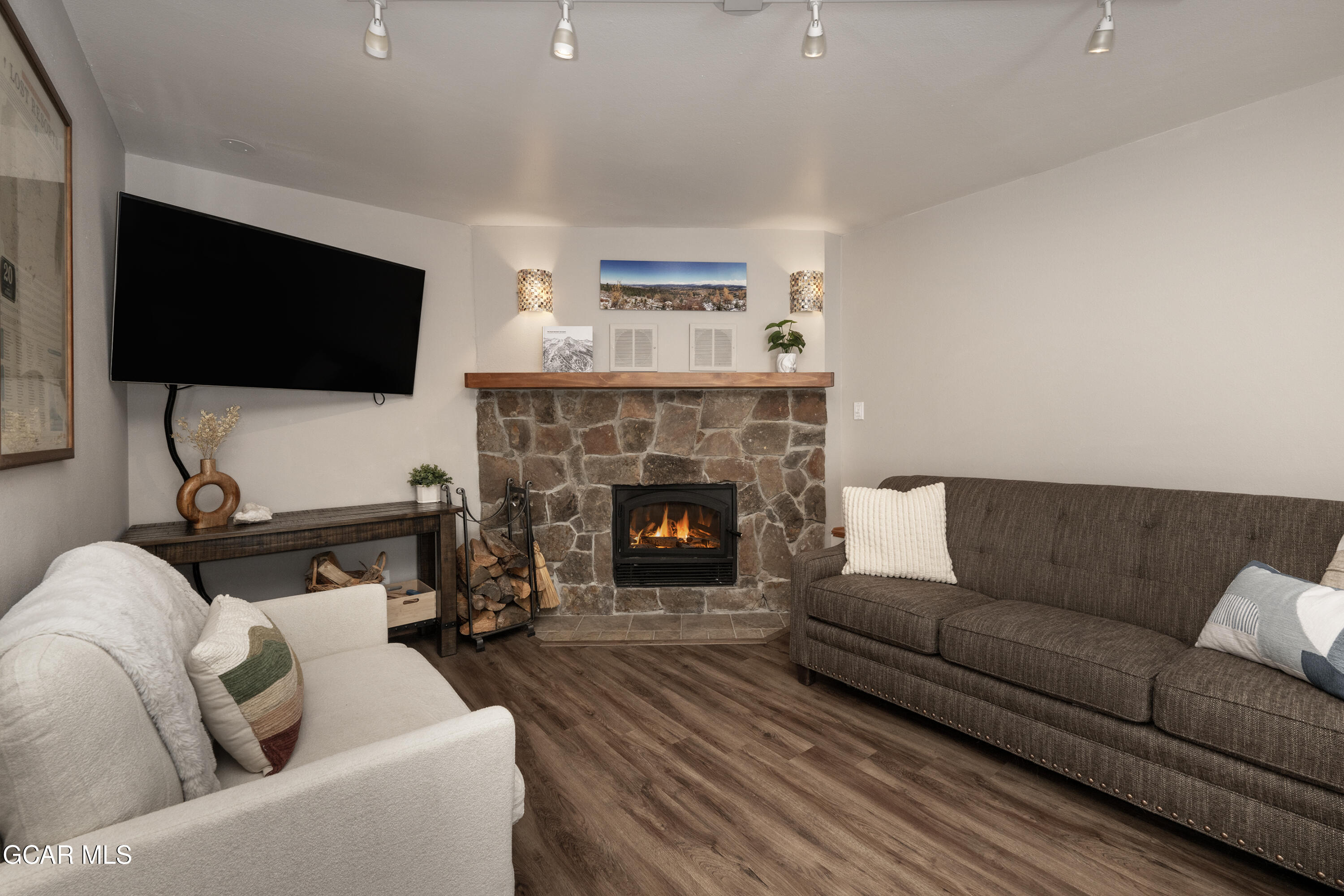 a living room with furniture a flat screen tv and a fireplace