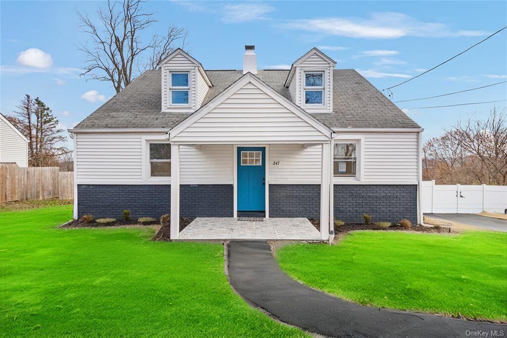 Cape cod-style house featuring a front yard