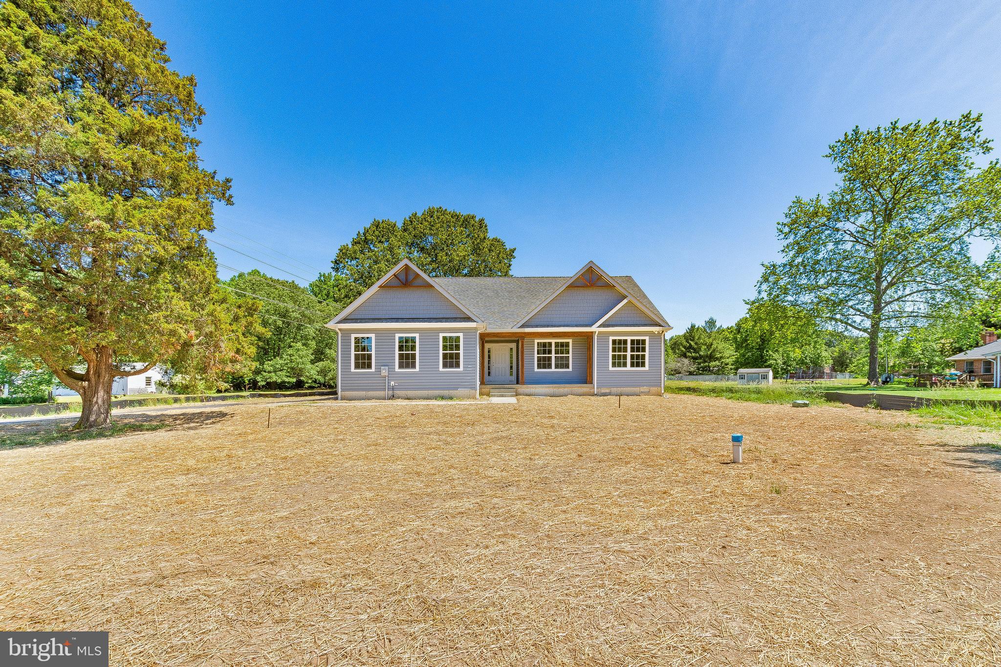 a front view of a house with a yard and trees