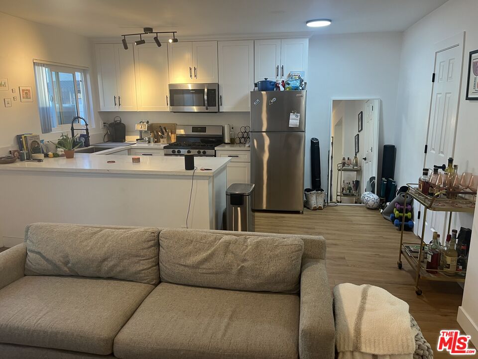 a living room with furniture and a refrigerator