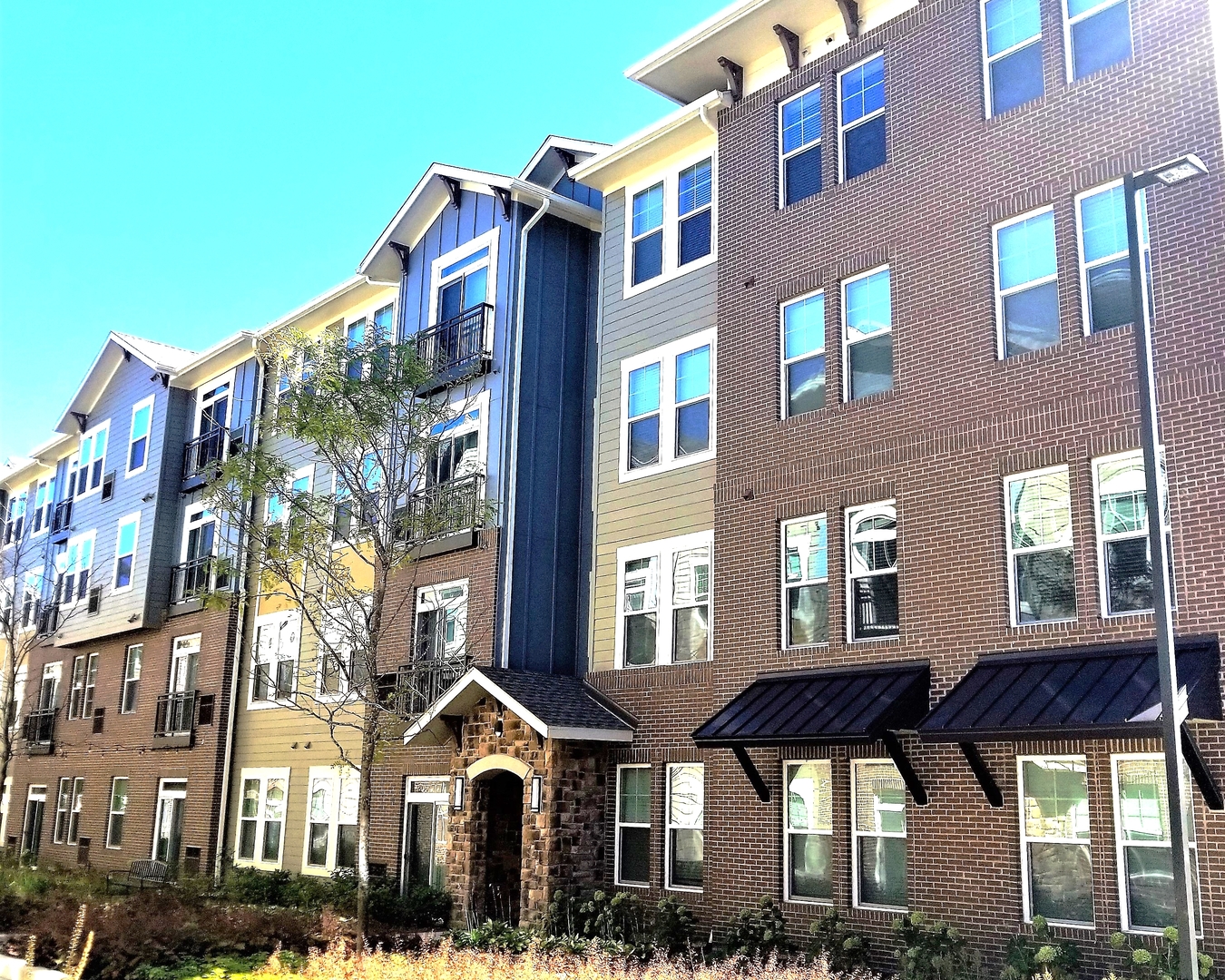 a front view of a residential apartment building with a yard