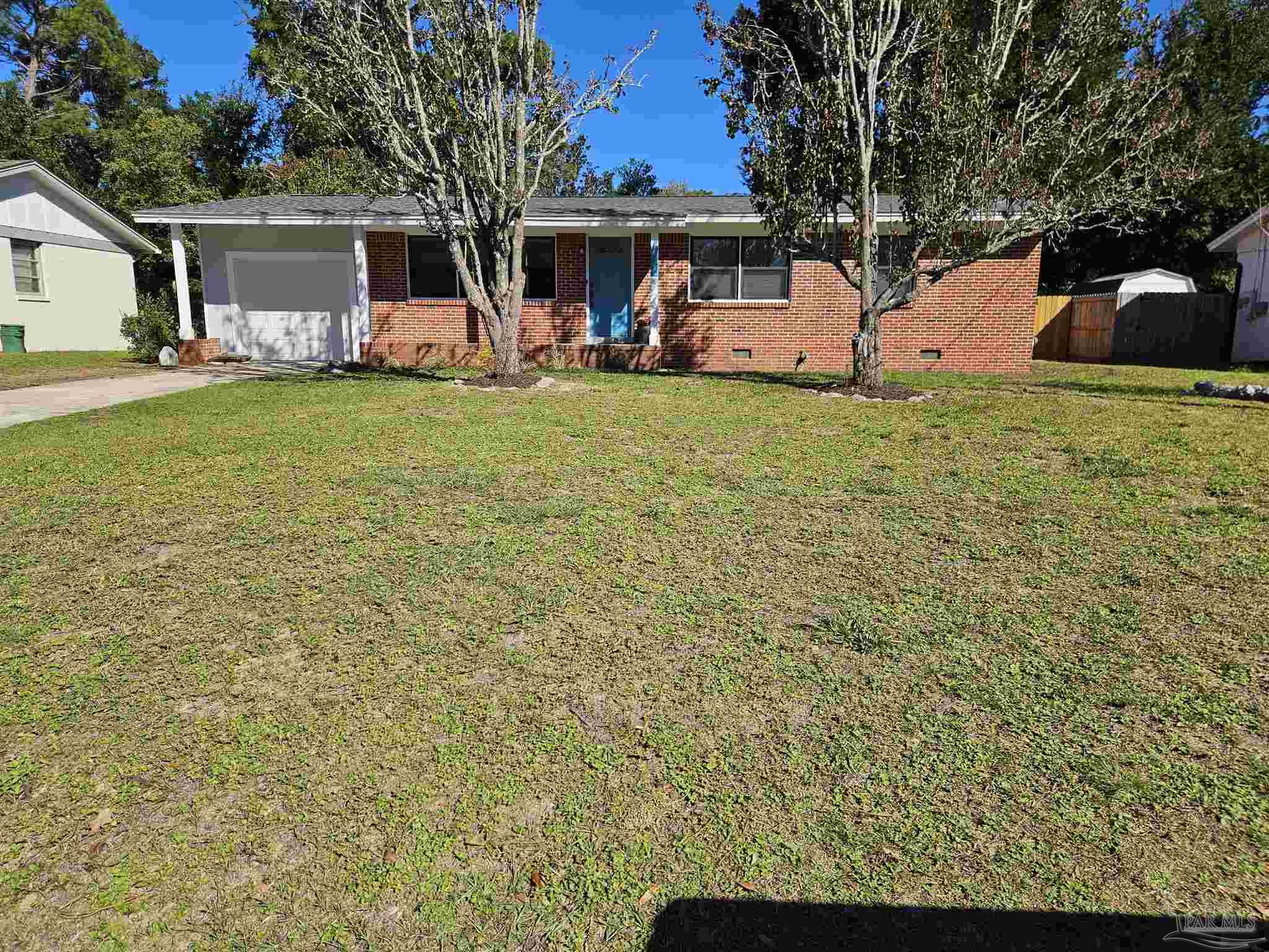 a view of a house with backyard and trees