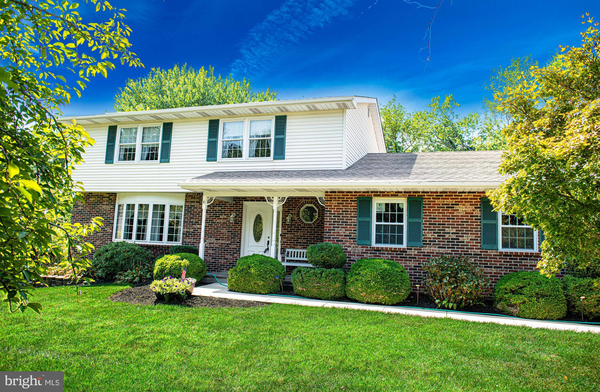 a front view of a house with a yard and potted plants