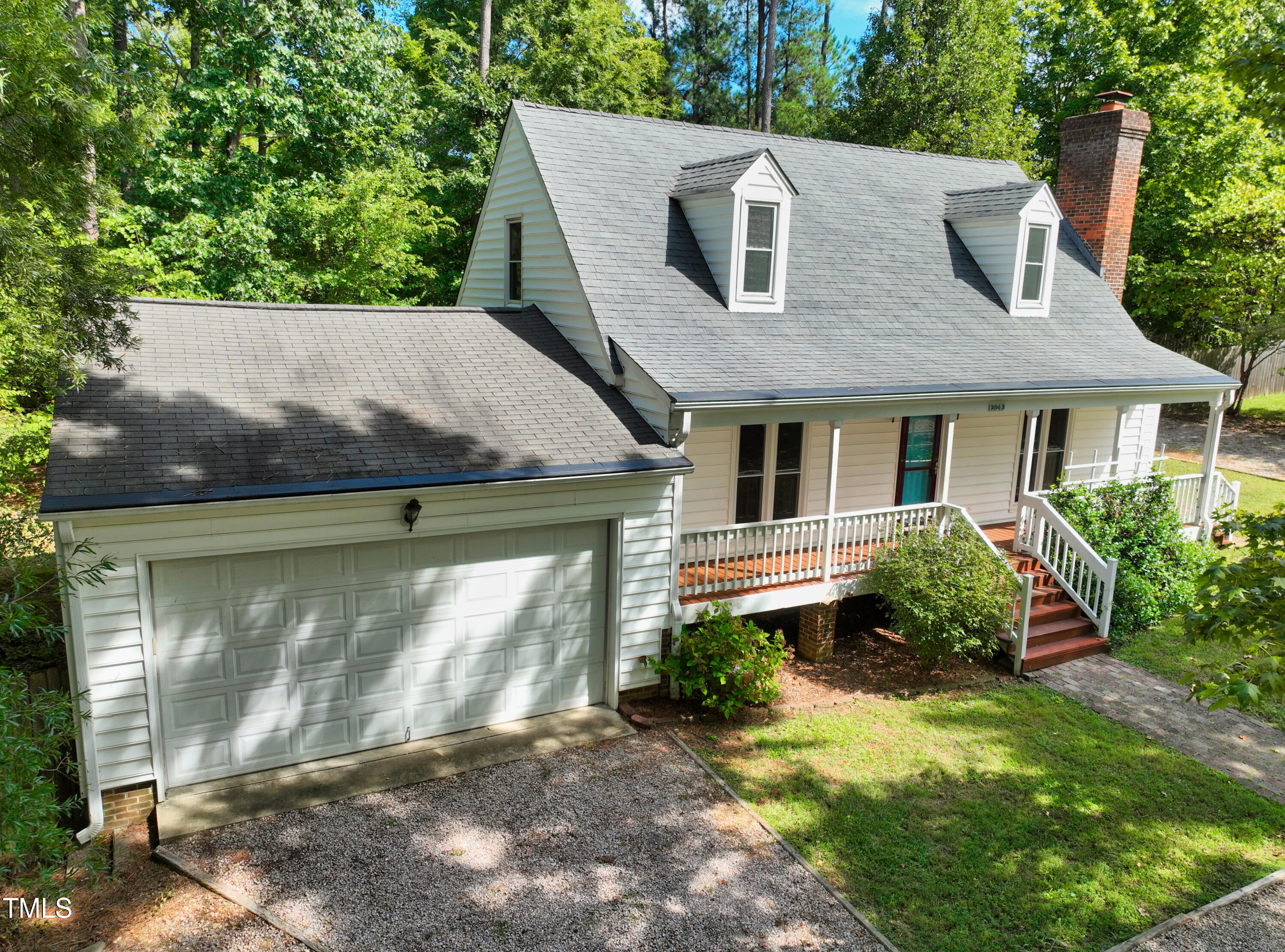 a aerial view of a house with yard and green space