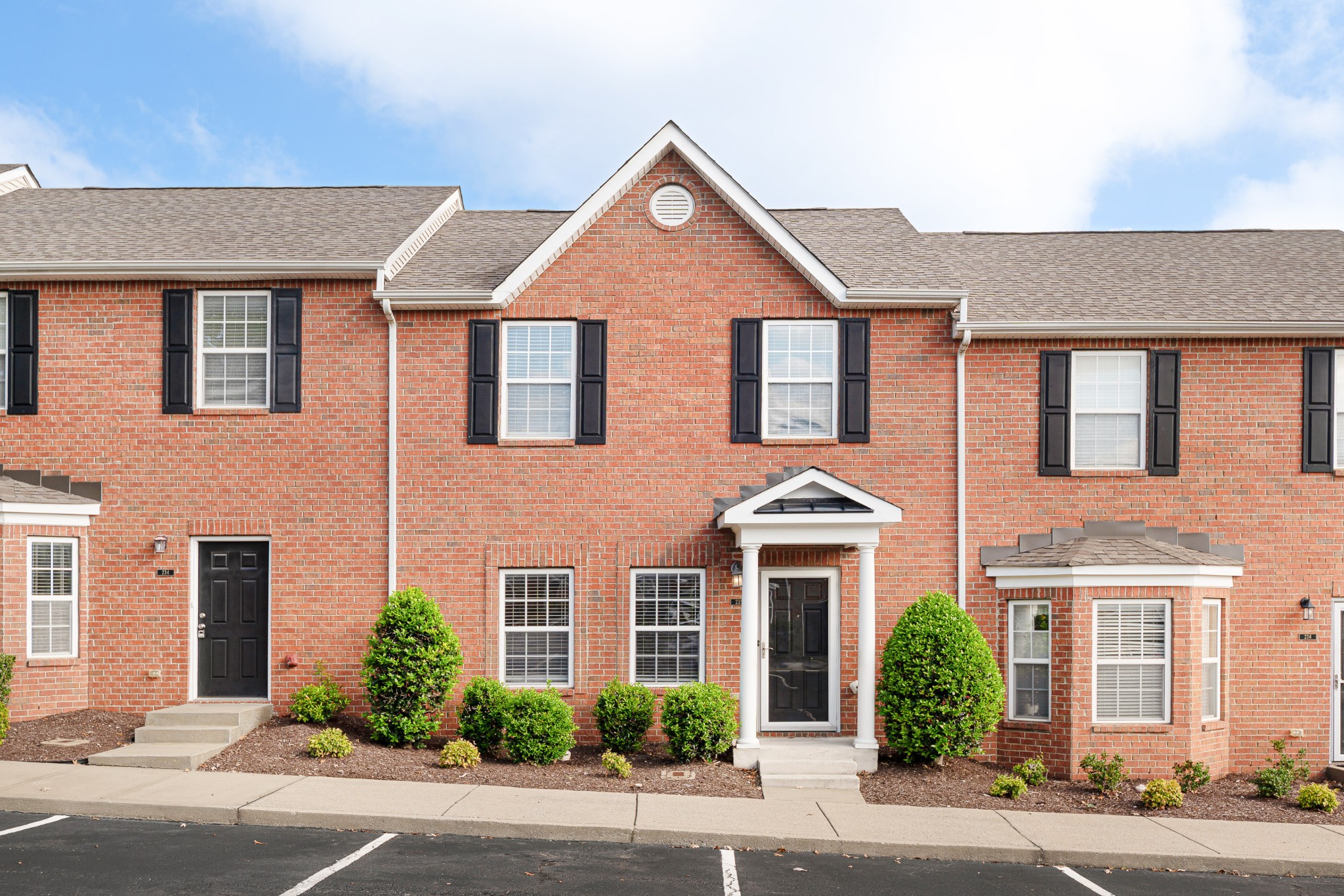 front view of a brick house with a yard