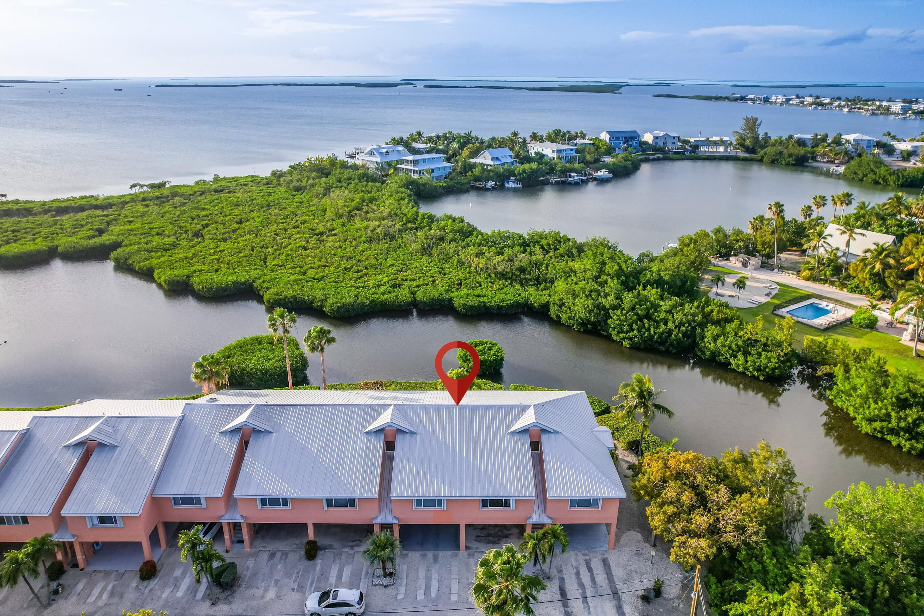 an aerial view of a house with a yard and lake view