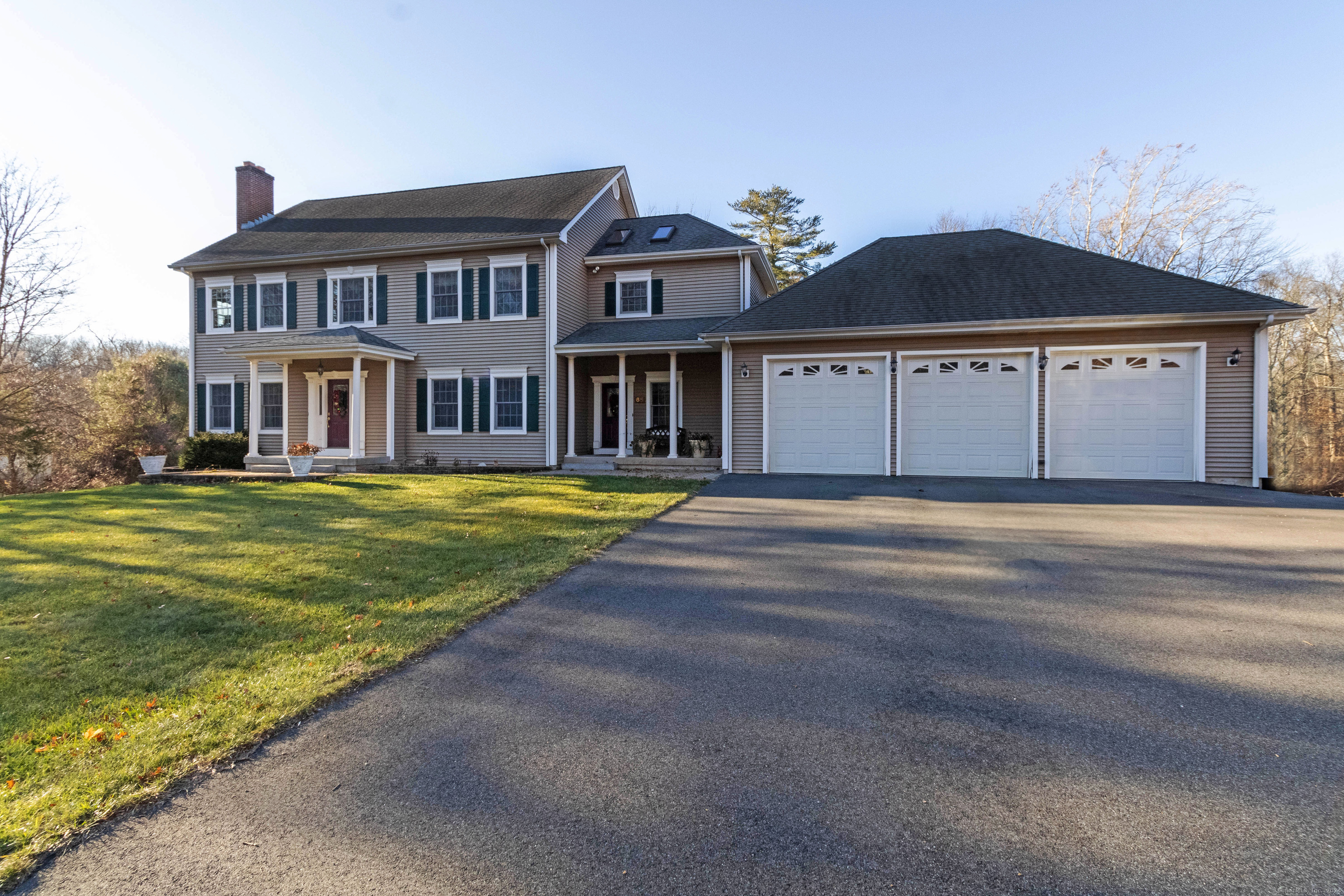 a view of a big house with a big yard and large trees