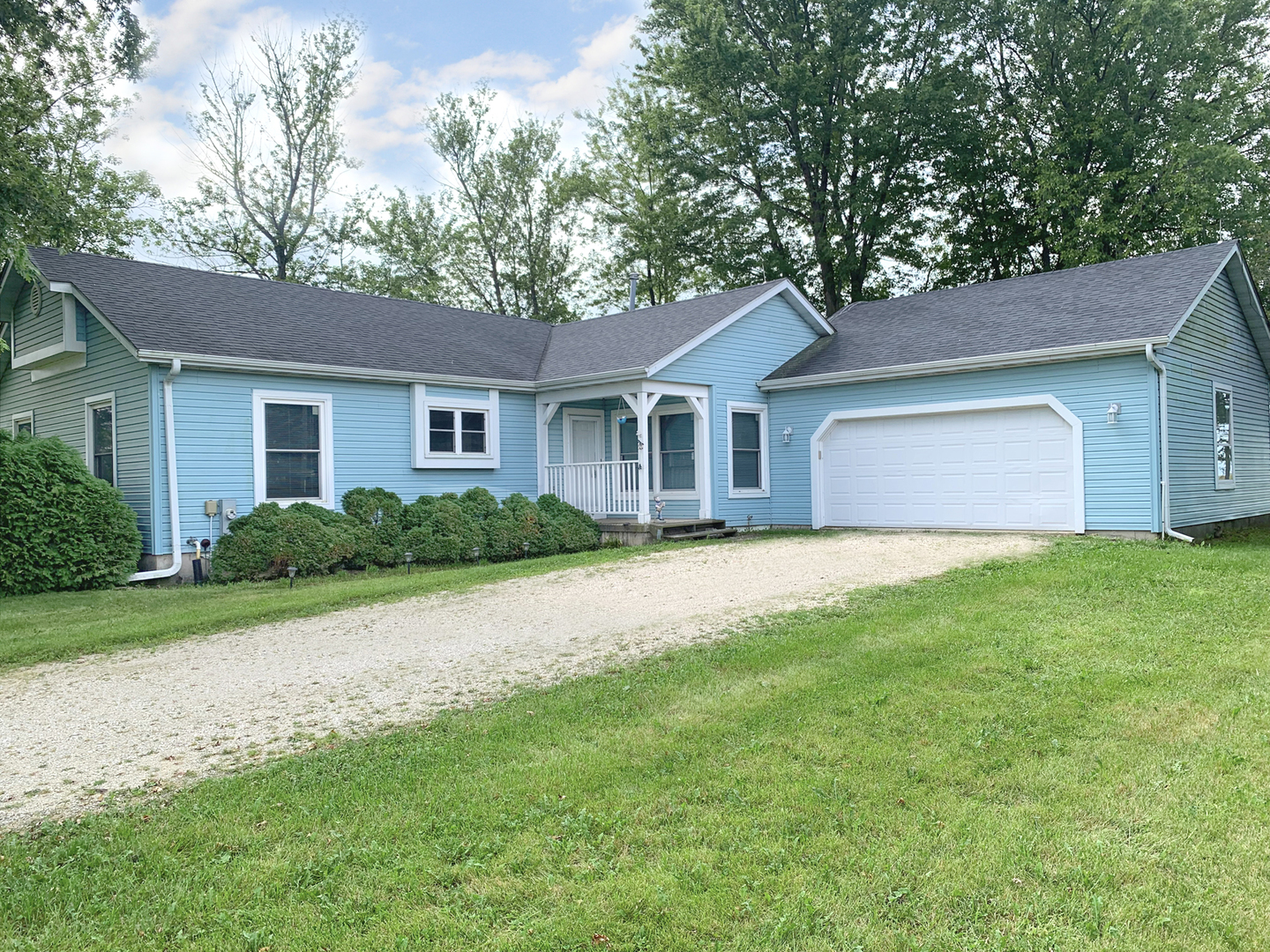 a house that is sitting in front of a big yard with large trees