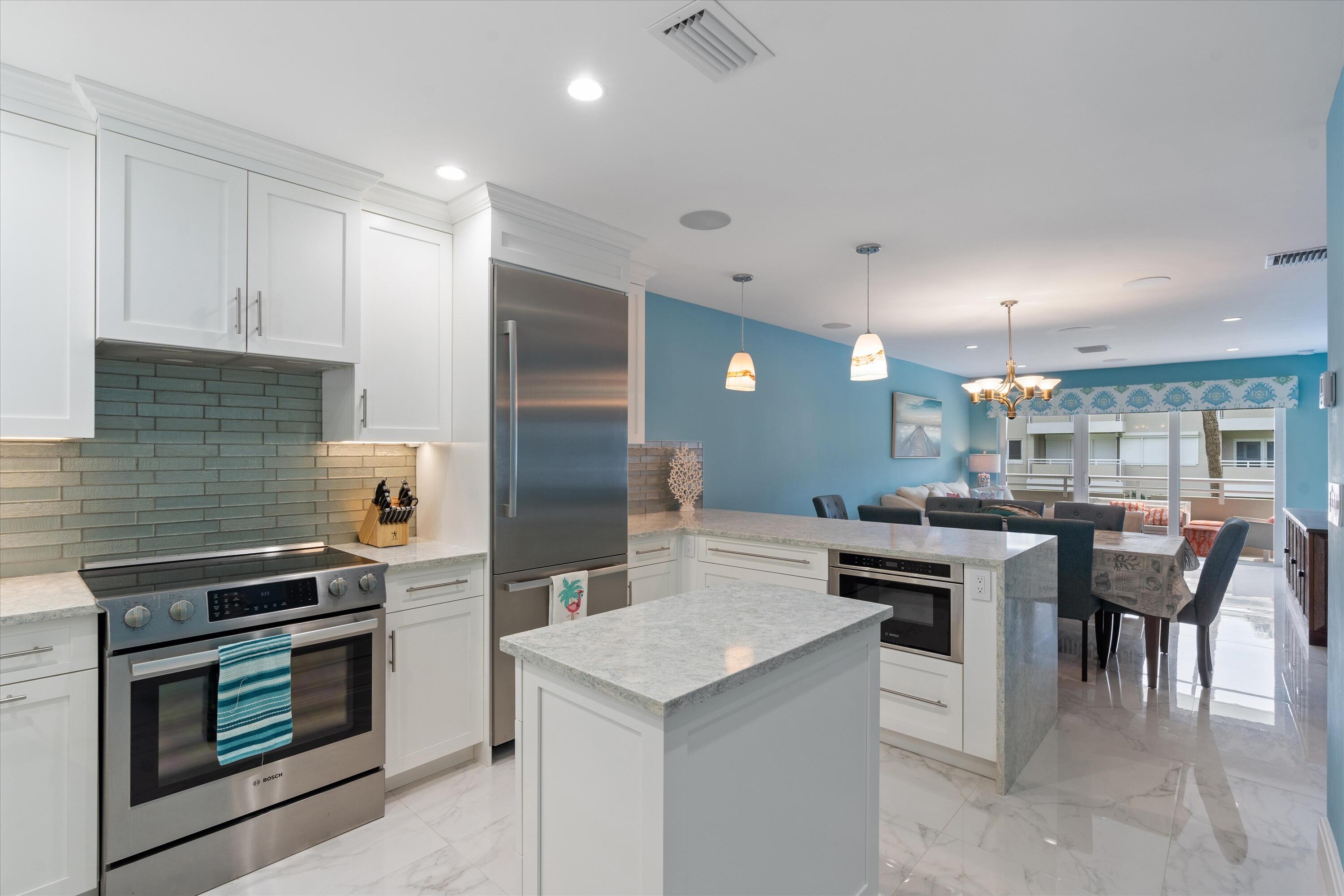 a kitchen with kitchen island stainless steel appliances a stove sink and microwave