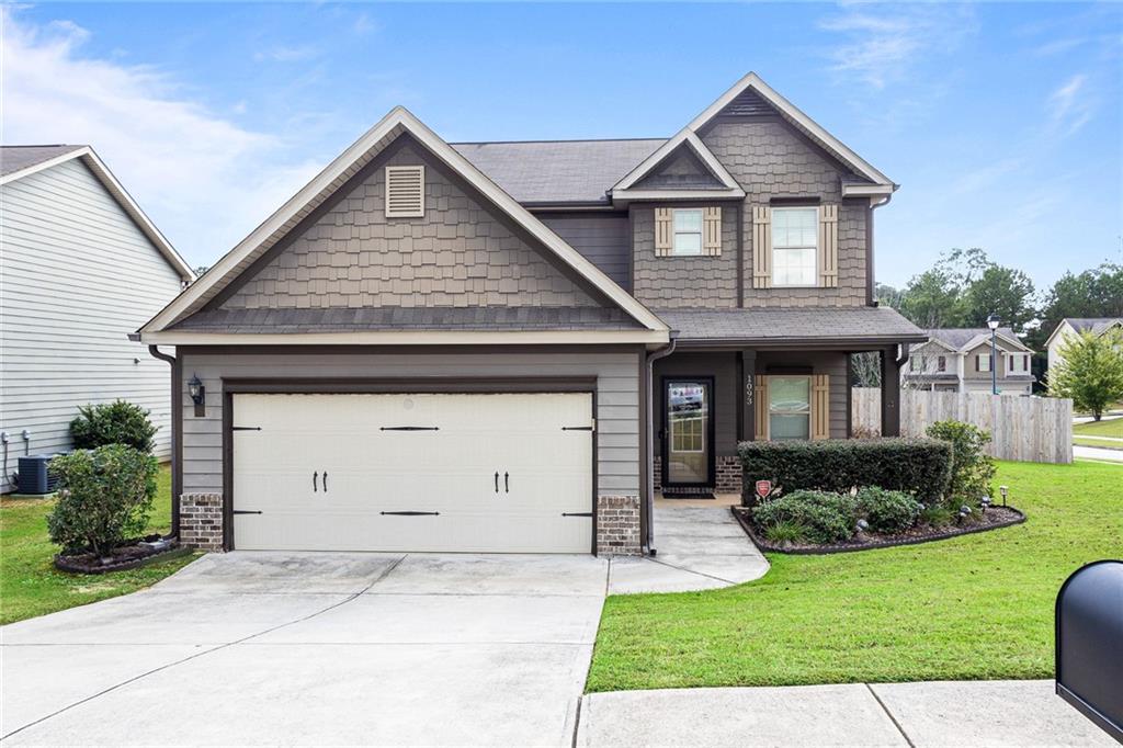 a front view of a house with a yard and garage