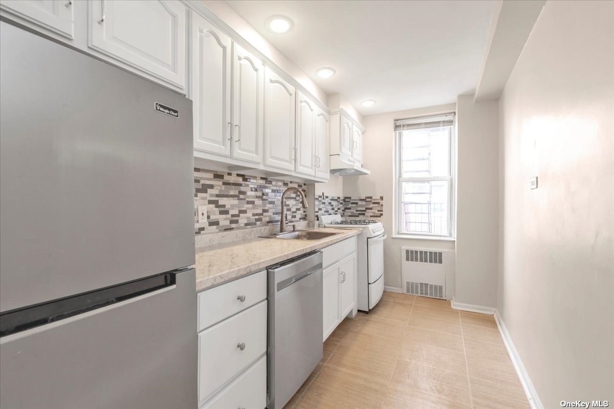 a kitchen with granite countertop white cabinets and white appliances