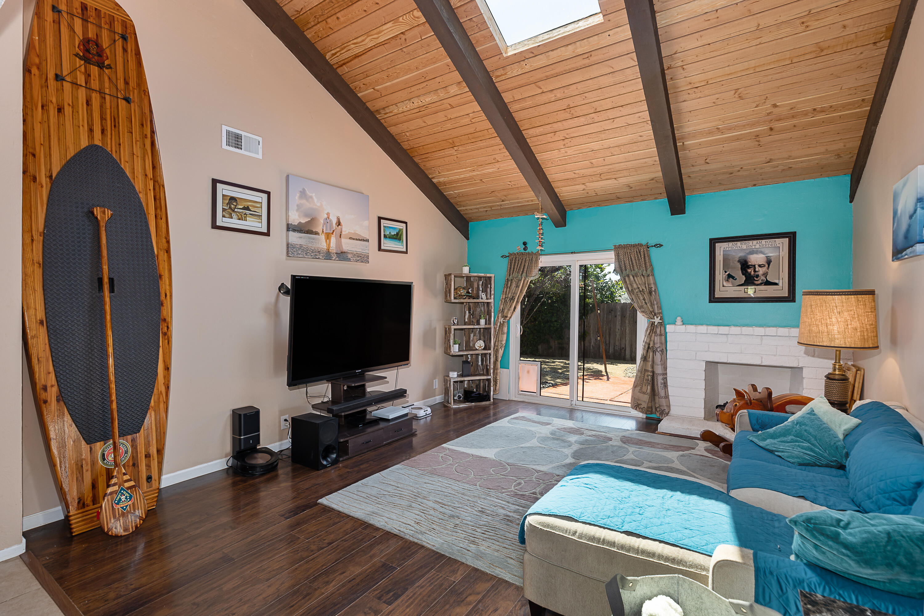 a living room with furniture a flat screen tv and a floor to ceiling window