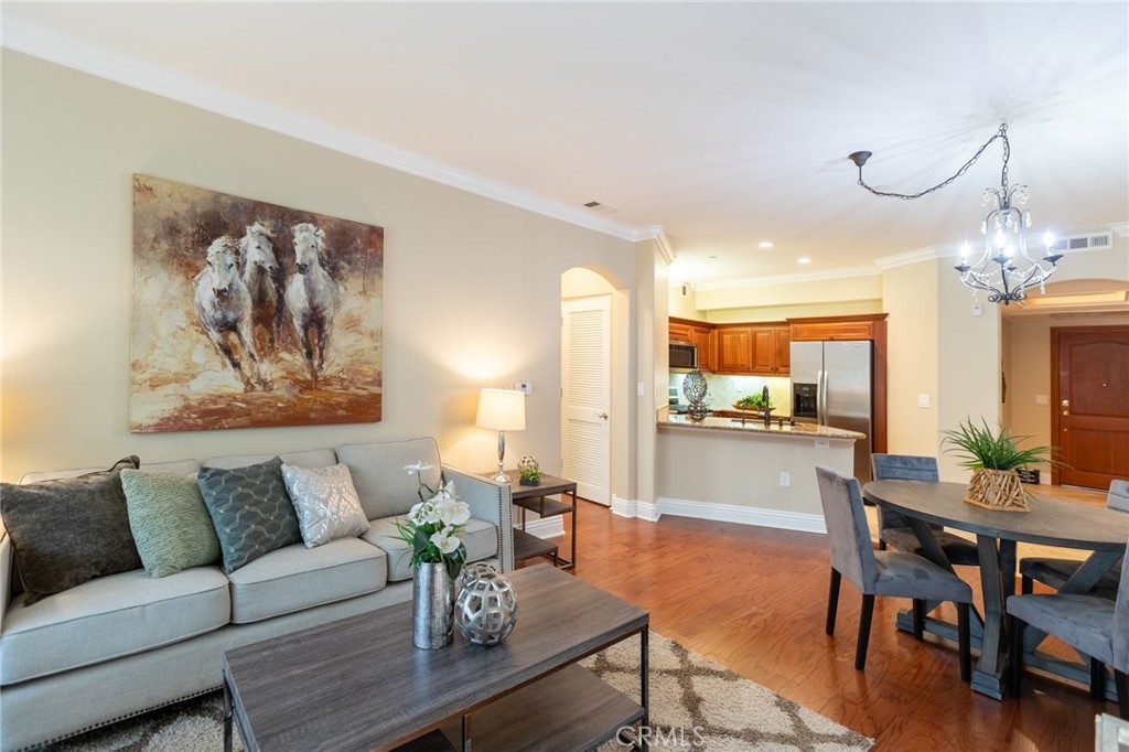 a living room with furniture a chandelier and a dining table