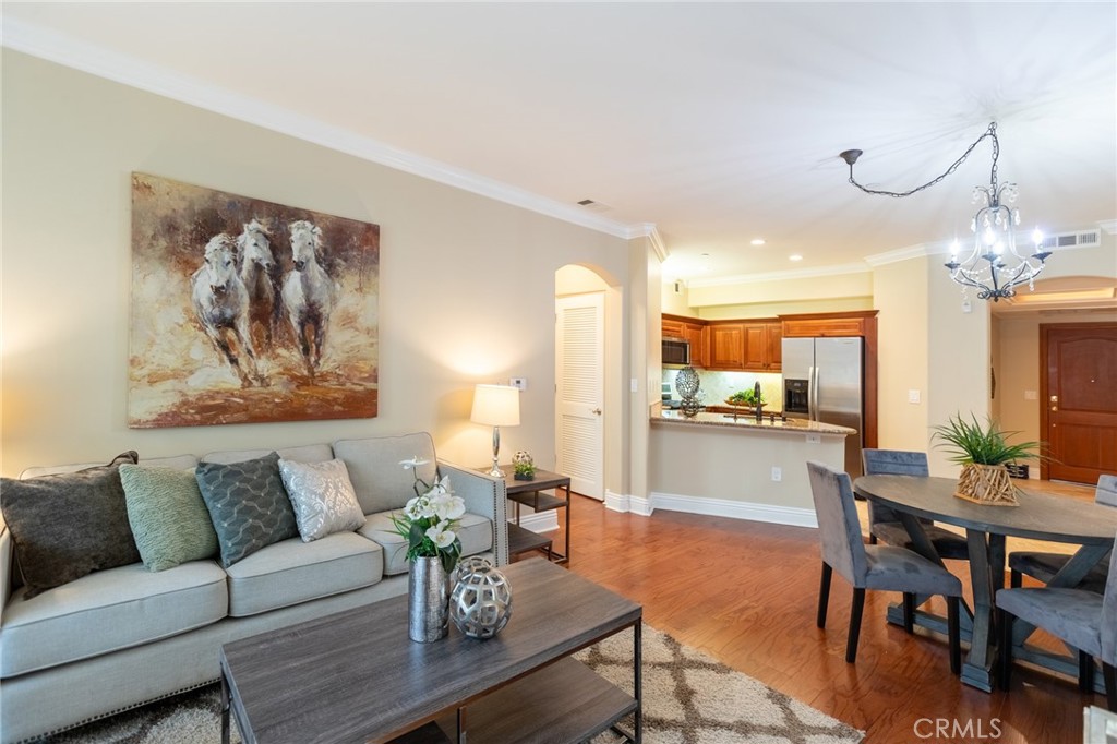 a living room with furniture a chandelier and a dining table