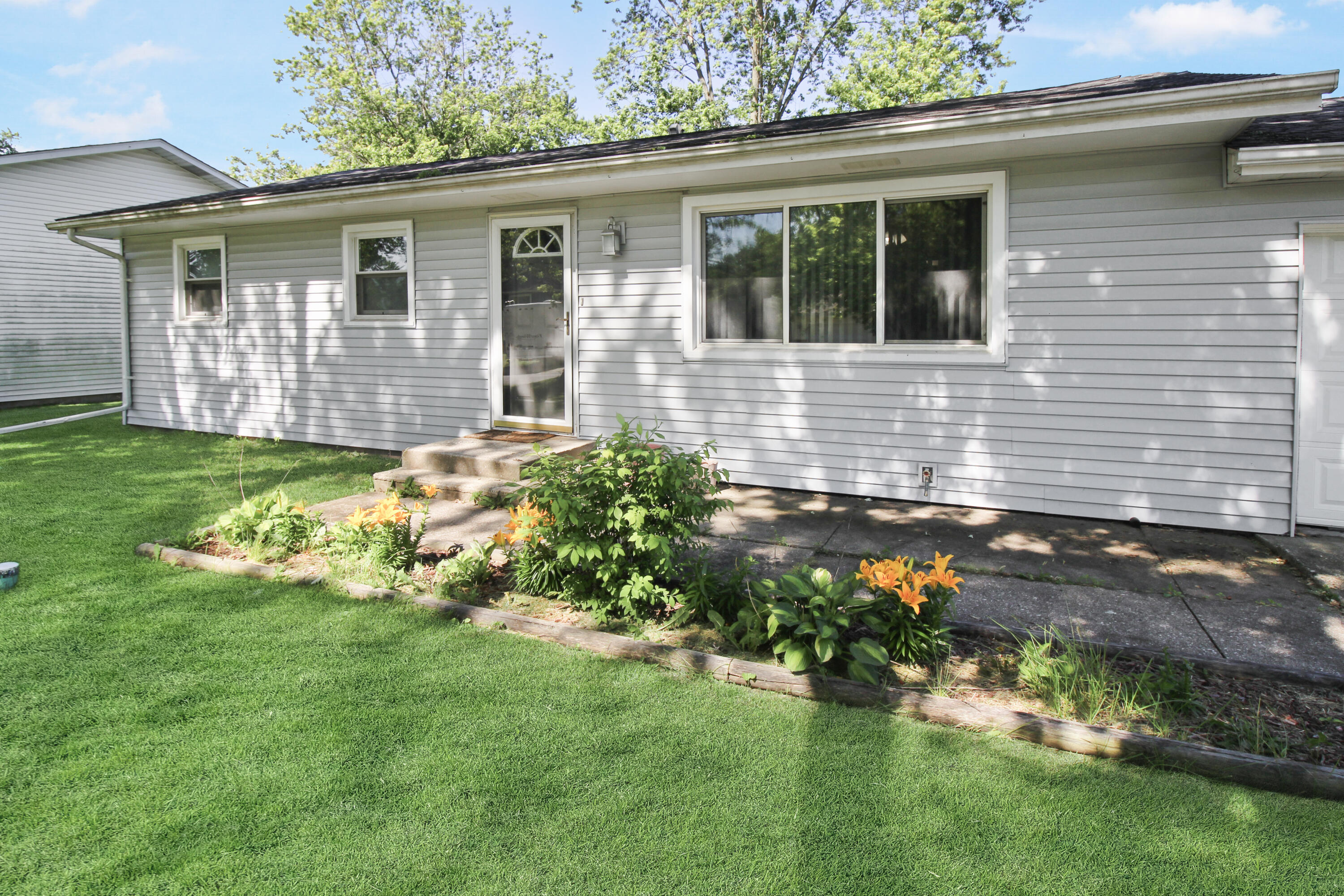 a front view of a house with a yard and potted plants