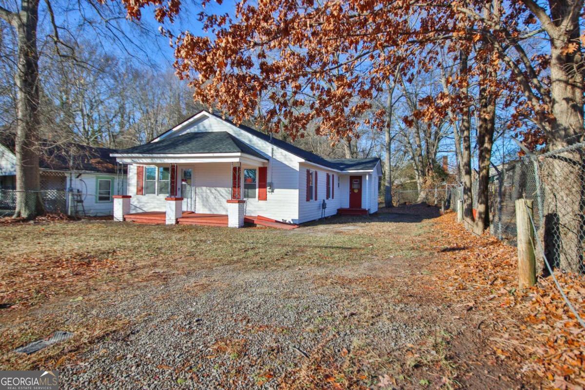 a front view of a house with a yard covered with trees