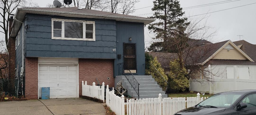 a view of a house with a door and wooden fence