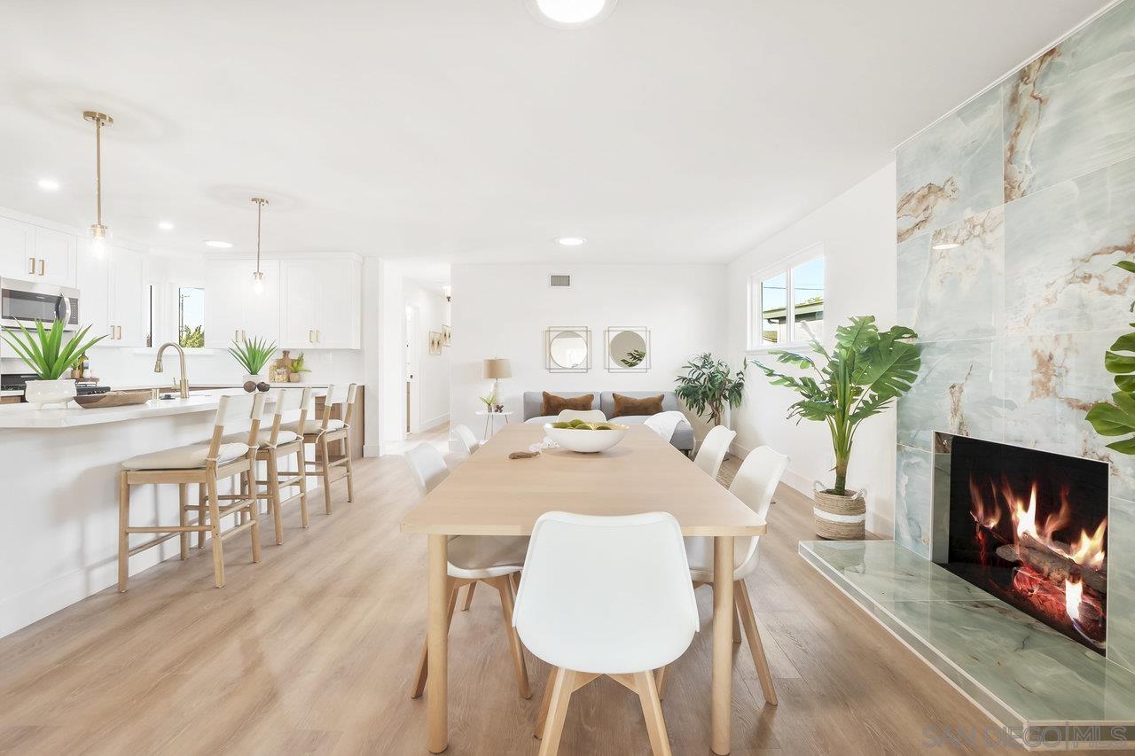 a dining room with furniture a fireplace and wooden floor