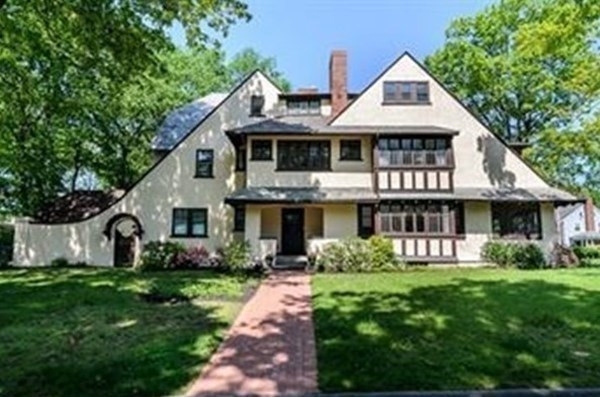 a view of a white house with a yard and potted plants