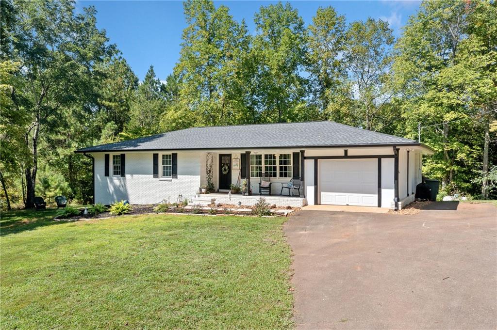 a front view of a house with a yard and trees