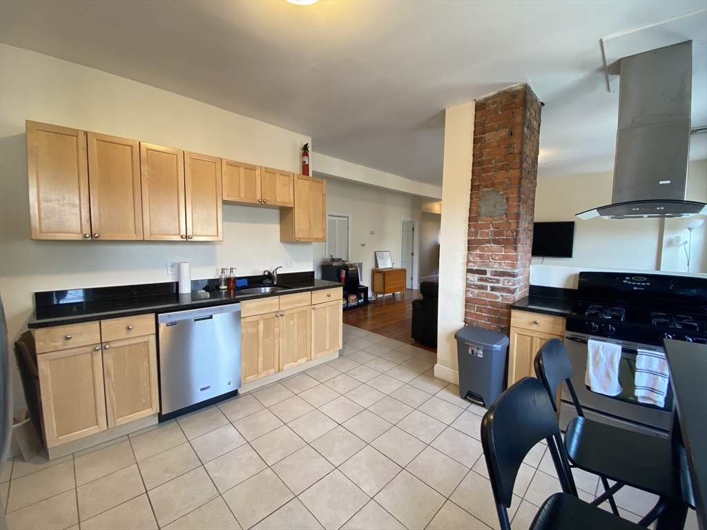 a kitchen with granite countertop a sink cabinets and stainless steel appliances