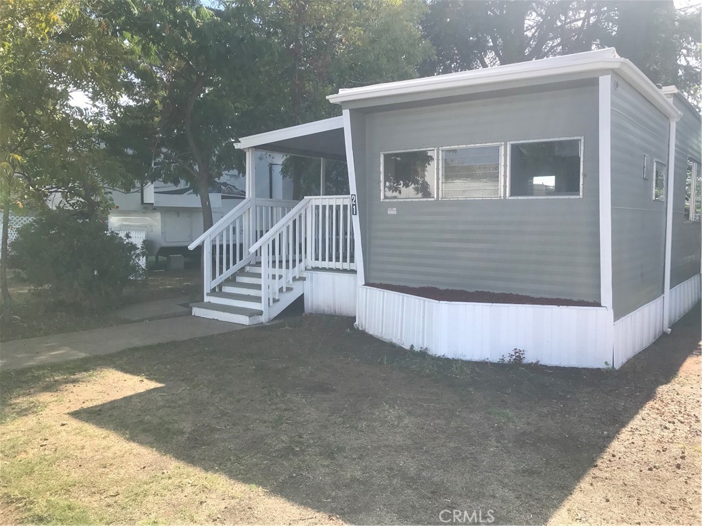 a view of a house with a wooden deck and a yard