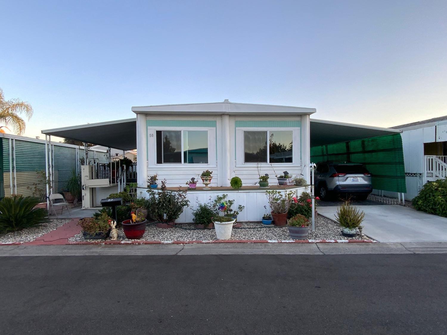 a front view of a house with sitting area and garden