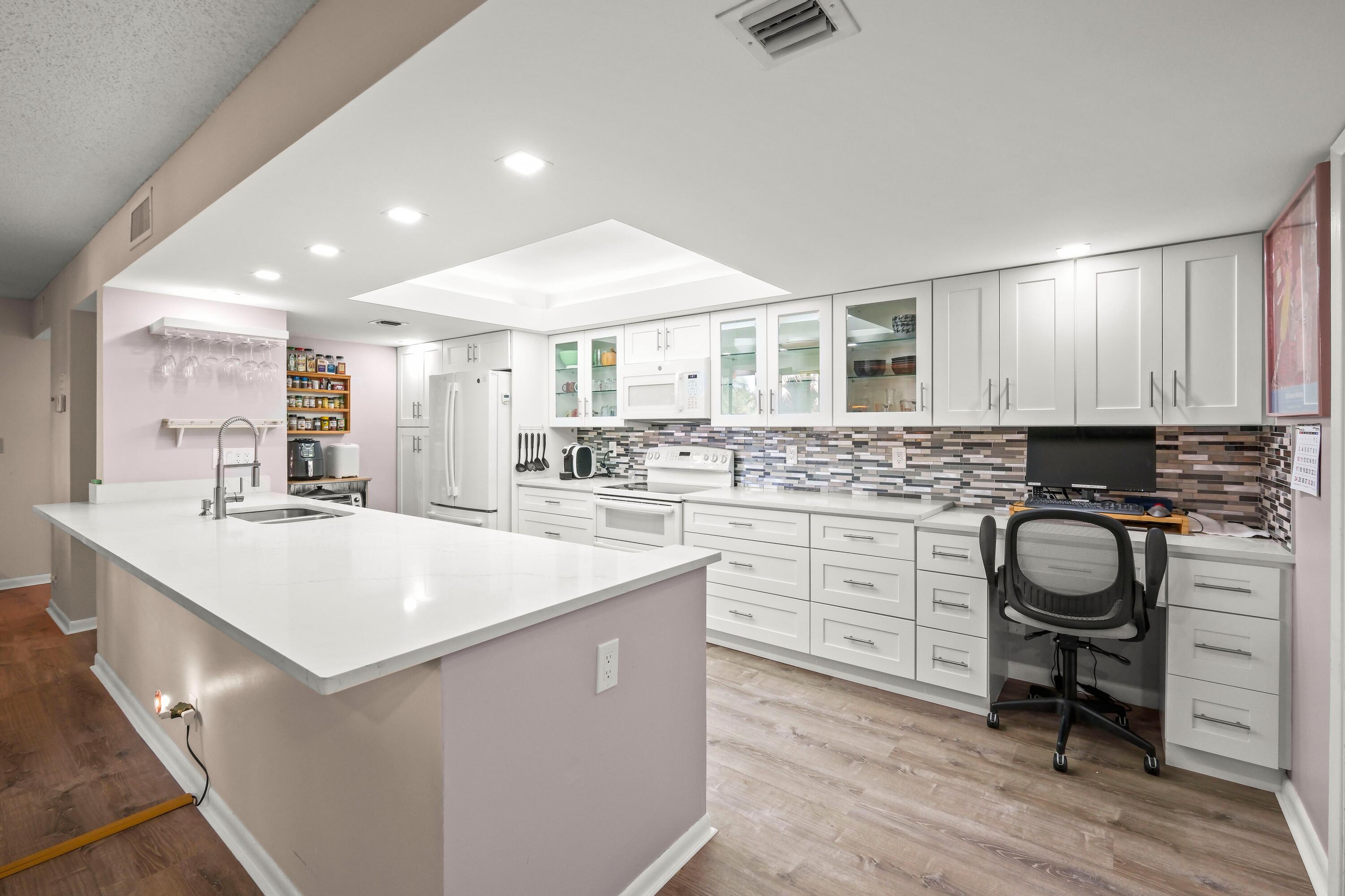 a kitchen with a sink cabinets and wooden floor